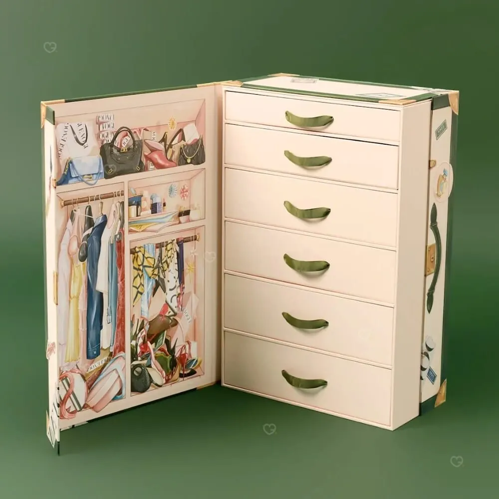 La malle ouverte, doublure dressing illustrée et six tiroirs